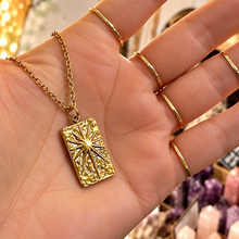 Load image into Gallery viewer, Gold rectangle starburst pendant held in the hand - Let's Jam, Camden Market
