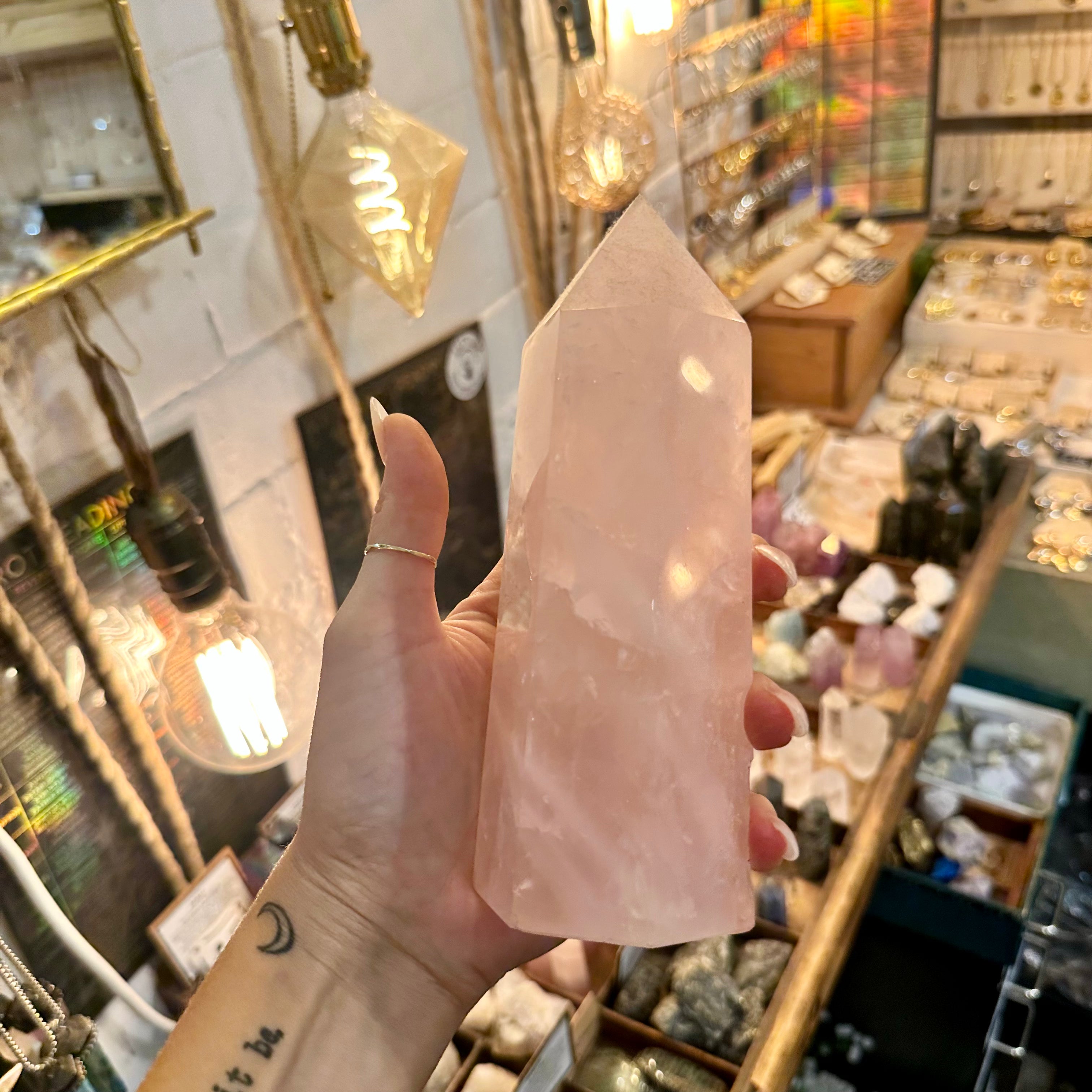 Tall rose quartz pointy tower held up in the shop - Let's Jam, Camden Market London