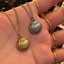 Load image into Gallery viewer, Gold and silver scallop shell pendants held in the hand - Let's Jam jewellery, Camden Market, London
