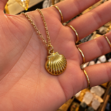 Load image into Gallery viewer, Gold scallop shell pendant held in the hand - Let's Jam, Camden Town London
