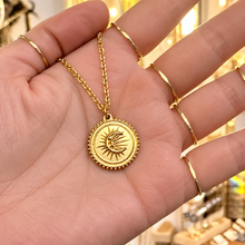 Load image into Gallery viewer, Gold sun and moon medal pendant held in the hand - Let's Jam, Camden Market
