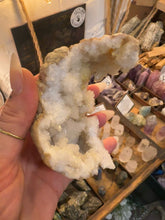 Load image into Gallery viewer, Natural geode lined with glittering white crystals, held in the hand - Let's Jam, Camden Market

