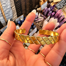 Load image into Gallery viewer, Gold squared plait cuff bangle held in the hand - Let's Jam, Camden Market London
