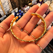 Load image into Gallery viewer, Woven gold cuff laid open in the palm - Let's Jam, Camden Market
