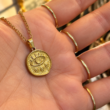 Load image into Gallery viewer, Gold third eye medallion held in the hand - Let's Jam, Camden Market London
