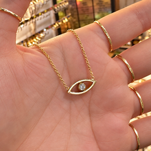 Load image into Gallery viewer, Gold third eye pendant with a sparkling stone held in the hand - Let's Jam, Camden Market
