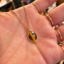 Load image into Gallery viewer, Faceted tiger's eye tear drop pendant in a gold setting held in the hand - Let's Jam jewellery, Camden Town London
