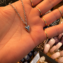 Load image into Gallery viewer, Tiny silver puffed heart pendant held in the hand - Let's Jam, Camden Market
