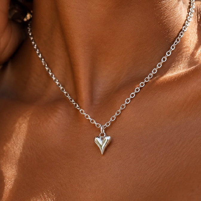 Close-up of a tiny silver puffed heart pendant necklace worn - Let's Jam, Camden Town