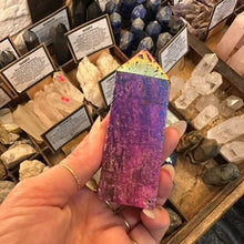 Load image into Gallery viewer, Titanium quartz obelisk in pink and purple held in the hand in the shop - Let's Jam, Camden Market
