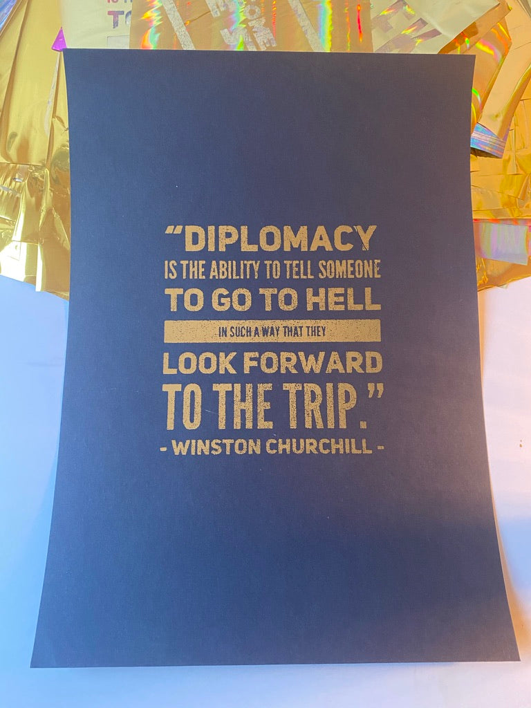 Navy A4 print with gold foil Winston Churchill diplomacy quote, shown against an iridescent gold backdrop - Let's Jam print collection