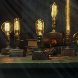 Wooden Edison bulb lamps of varying heights glowing warmly, styled among stacked vintage books in a moody, atmospheric setting - Let's Jam collection
