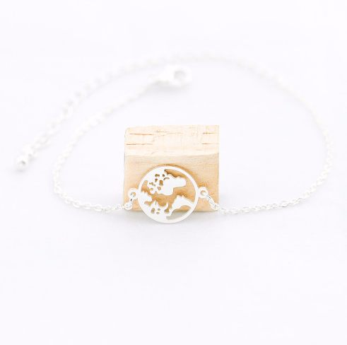 Tiny world charm bracelet worn on the wrist, chain resting on skin - Let's Jam jewellery, Camden Market, London