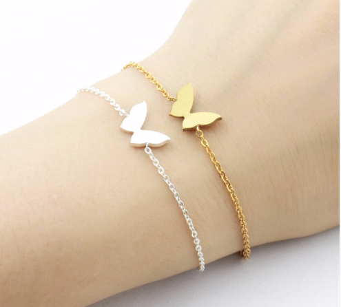 Gold and silver small butterfly charm bracelets stacked on wrist - Let's Jam jewellery collection