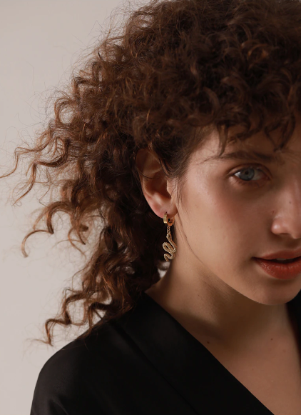 Gold-plated stainless steel snake drop earring shown close against the ear - Let's Jam jewellery, Camden Market