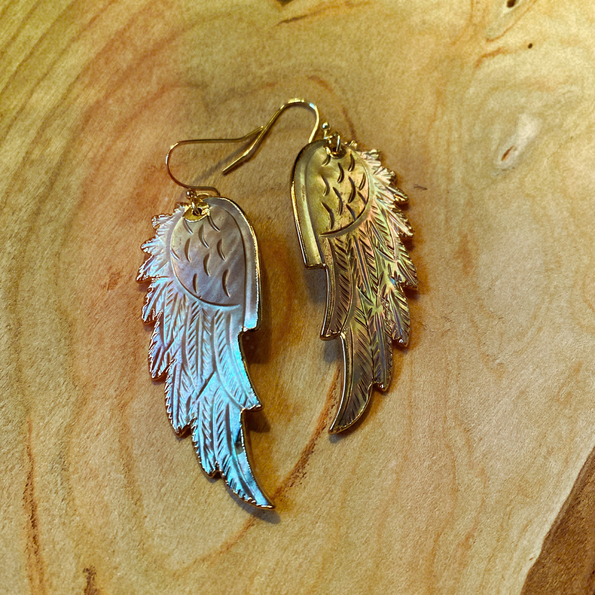 Silver-grey mother of pearl wing earrings hanging from fine gold hooks - Let's Jam jewellery, Camden Market, London