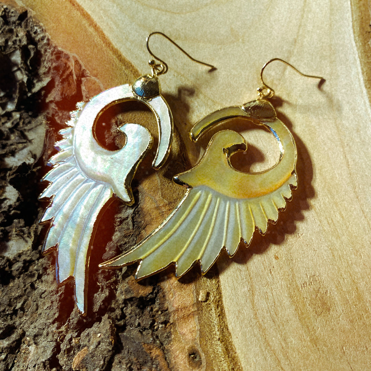 Swirled yellow mother of pearl wing earrings resting on tree bark - Let's Jam, Camden Town London