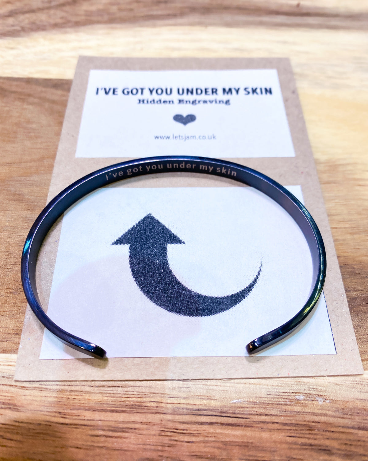 Cuff bracelet held in hand, smooth outer surface facing the camera - Let's Jam, Camden Town